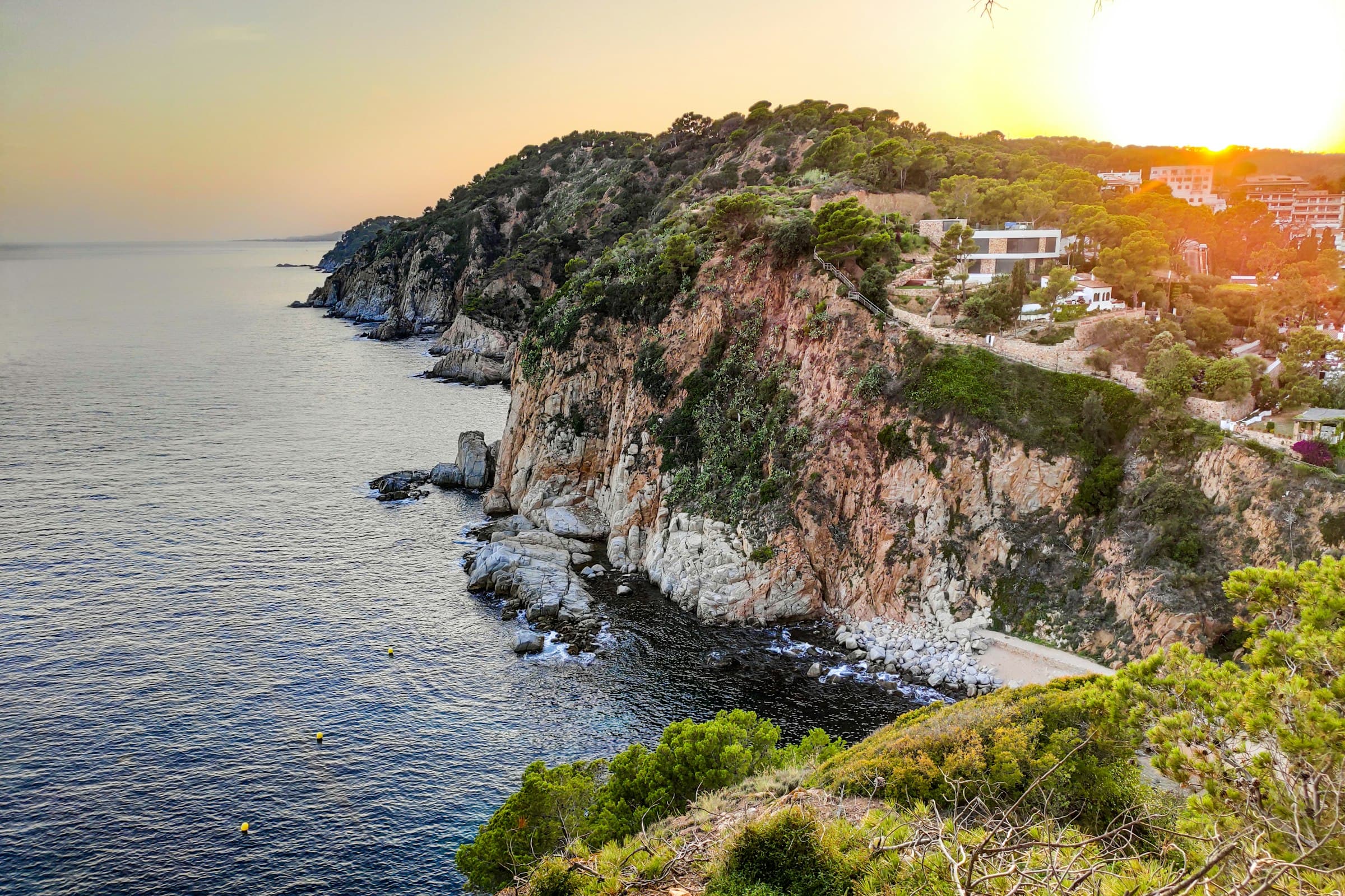 Rocky Spanish Mediterranean coastline at sunset with villas above the sea